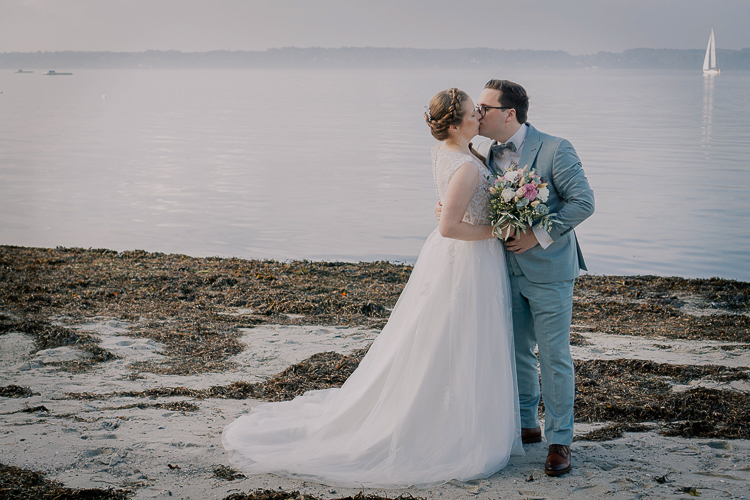 Brautpaar küsst sich am Meer